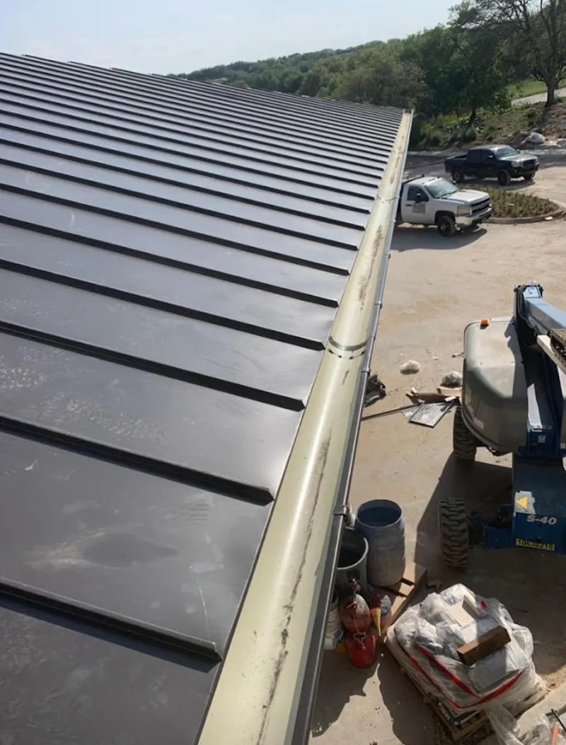 Standing seam panel and gutter detail on a metal roofing jobsite in Plainfield